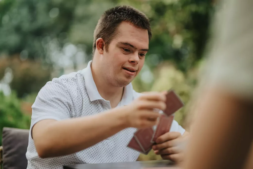 Disabled man with down syndrome playing card game