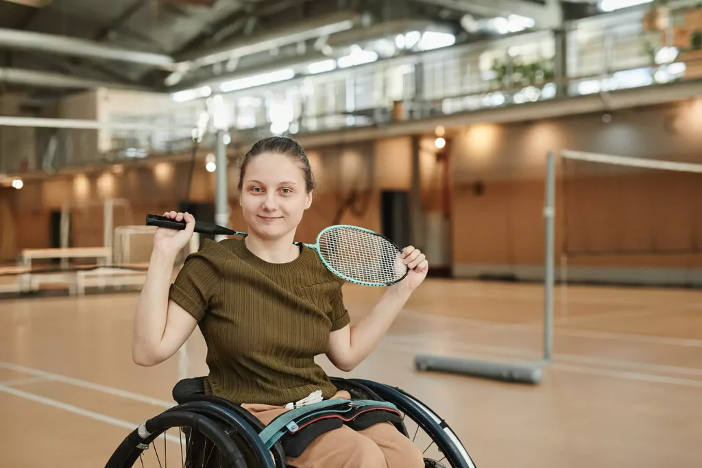 Disabled girl in wheelchair holding badminton bat
